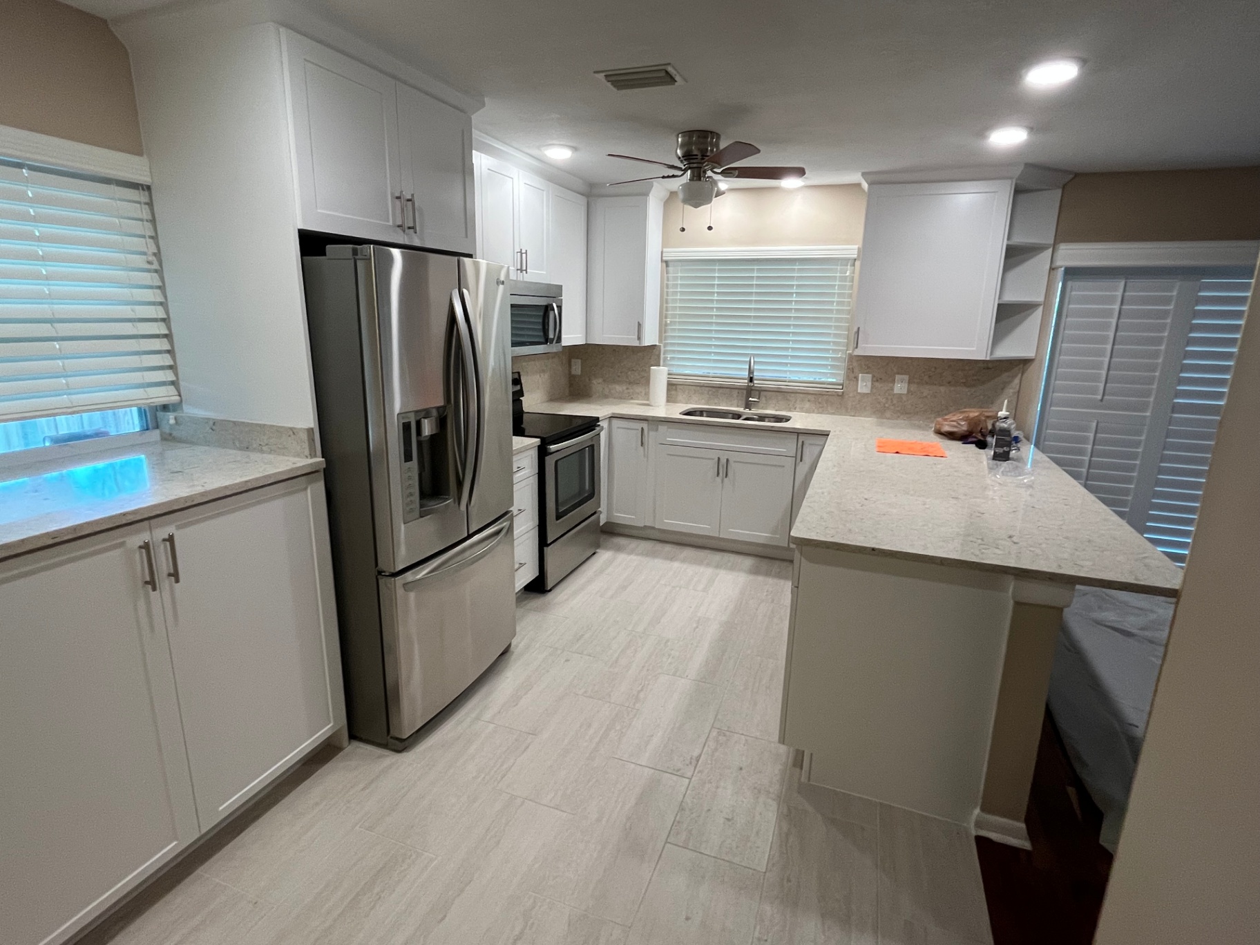 Finished kitchen with white shaker cabinets and quartz counters